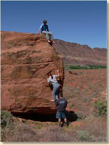 Jeremy, Heidi and Daniel climbing boulder face