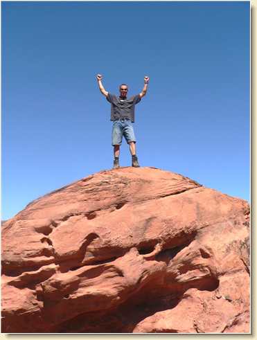 Daniel Adams on top of bouldering rock at DayStar Academy