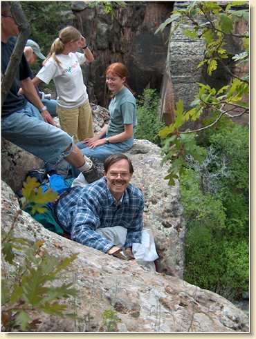 Fred Adams happily perched on cliff ledge to watch rappelling
