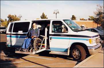 Fred Adams in wheelchair on ramp of his dandy handicap van