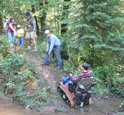 Fred in TracAbout being pulled up creek bank